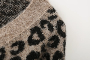 Détail d'un cardigan en tricot léopard à col en V montrant la texture et les coutures