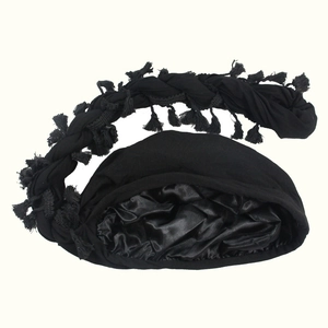 Black beanie with braided tassel and glossy satin lining shown on a white background