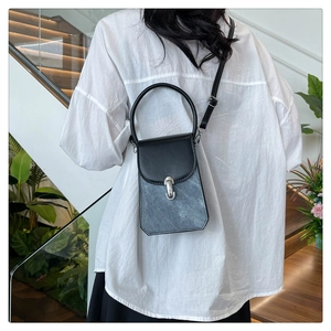 Detail of the black and grey textured crossbody bag featuring silver metal buckle
