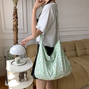 Floral canvas tote bag shown as a shoulder bag on a model in a cozy interior setting