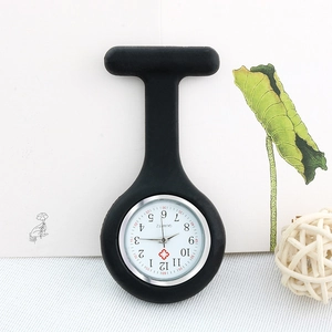 Detail of a black silicone nurse fob watch with a white quartz dial and red cross symbol
