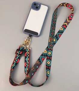 Detail of colorful woven ethnic pattern phone strap with golden metal clasp and blue case