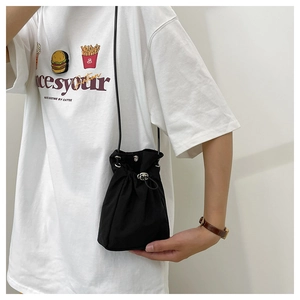 Close-up of a black drawstring bucket bag with metal eyelets and adjustable cord lock