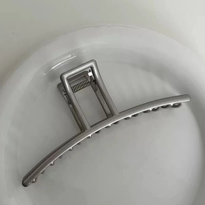 Detailed view of silver metal bow shark hair claw clip with polished finish and sleek teeth