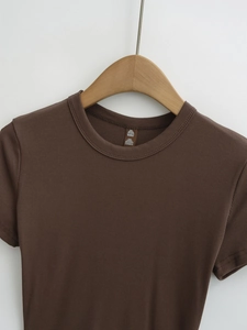 Gros plan sur la texture du tissu modal côtelé marron d'un t-shirt à manches courtes