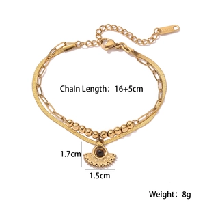 Detail of layered gold stainless steel bracelet with eye pendant and size specifications