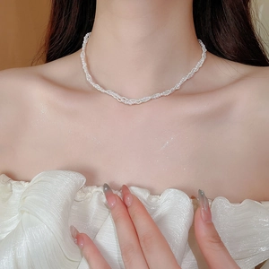 Close-up of triple-layered woven pearl choker necklace showing elegant spiral texture