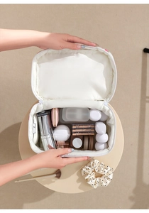 Spacious interior of white quilted butterfly makeup bag showing large storage capacity