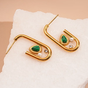 Macro detail of U-shaped gold earrings featuring green malachite, pearl and zircon accents