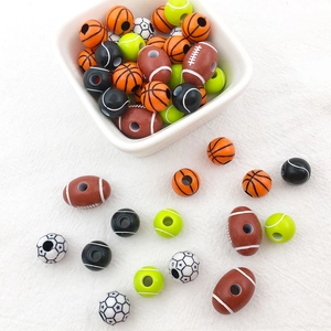 Detailed macro shot of various acrylic sports beads including basketball and soccer balls