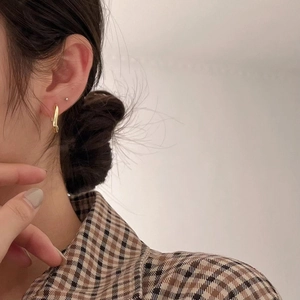 Minimalist 925 sterling silver gold curved stud earrings on a model with plaid shirt