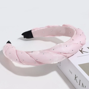 Pink woven satin headband with rhinestone embellishments on a minimalist white surface