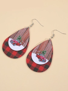 Detail of teardrop earrings featuring buffalo plaid and Christmas tree truck prints