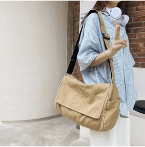 Detail of khaki washed canvas messenger bag featuring wide flap and adjustable strap