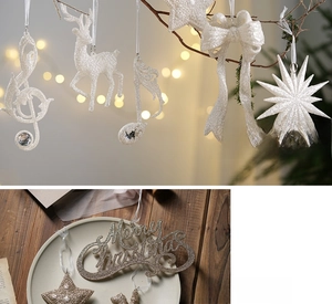 Detail of silver glitter Christmas ornaments with reindeer and star shapes hanging on tree