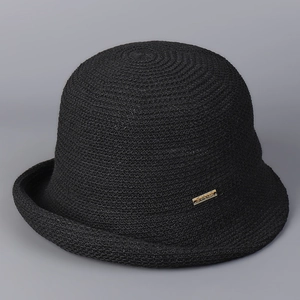 Close-up of black knit sun hat featuring a textured weave and gold rectangular plaque