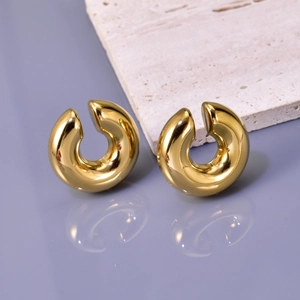 Polished 18K gold hollow C-shape titanium steel hoop earrings on a textured stone base