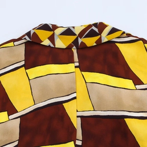 Dettaglio del colletto di una camicia casual con stampa geometrica astratta gialla e marrone