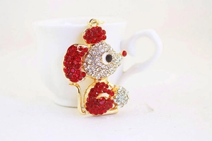 Detailed close-up of golden mouse keychain with sparkling red and clear rhinestones