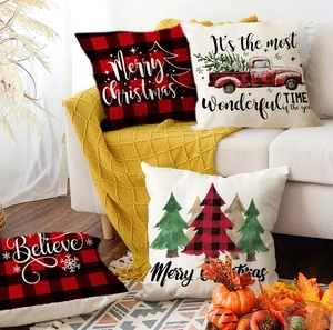 Set of 4 Christmas pillow covers with red truck and plaid patterns on a cozy sofa