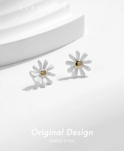 Detail of s925 silver daisy earrings with white enamel petals and gold center