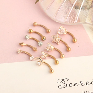 Macro view of eight rose gold curved barbells featuring heart, star and moon shapes