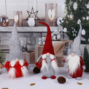 Three Christmas gnomes set with red and white hats on festive cozy background