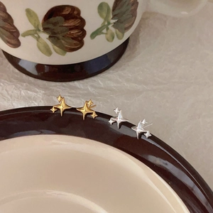 Minimalist 925 sterling silver star stud earrings in gold and silver finish on ceramic