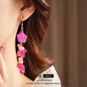 Boucles d'oreilles fleur en nacre rose avec perles portées par un mannequin