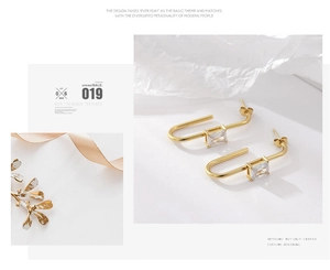 Detail of 18K gold U-shaped earrings featuring rectangular baguette-cut cubic zirconia
