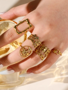 Set of 6 gold rings with tree of life and chain patterns worn by a model in warm light