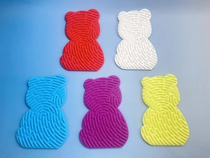 Bunte bärenförmige Silikon-Aktivitätspads mit strukturierten Oberflächen auf blauem Grund