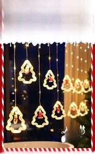 Detail of Christmas LED curtain lights with warm yellow tree-shaped ornaments and figurines