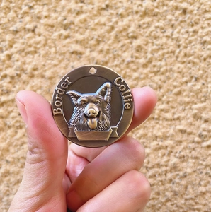 Antique bronze pet ID tag with embossed Border Collie design in a circular metal coin shape