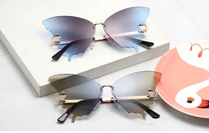 Detail of rimless butterfly wing sunglasses with gradient lenses and gold metal frames