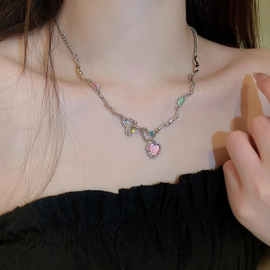 Gros plan du collier cœur avec pendentif opale rose et pierres de zircon sur chaîne argentée