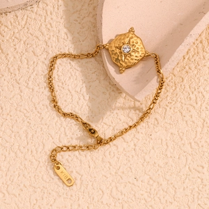 Macro detail of gold starburst bracelet with K18 hallmark on the extender clasp tag