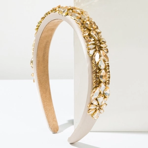 Vue détaillée d'un serre-tête en satin champagne avec motifs de fleurs en cristaux dorés