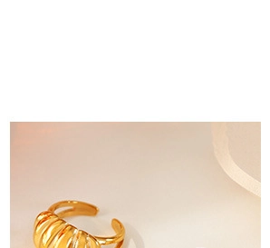 Détail d'une bague croissant dorée épaisse avec texture striée et anneau ajustable ouvert