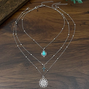 Collana boho a tre strati in argento con pendenti in turchese, croce e fiore tondo