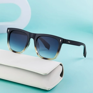 Fashion square frame sunglasses with blue gradient lenses on a white eyeglass case