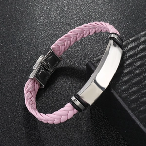 Detail of pink braided leather bracelet with stainless steel plate on black background