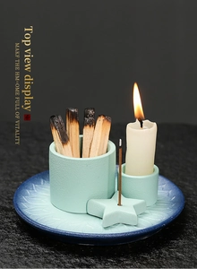 Top view of ceramic aromatherapy set with sage wood and candles on a patterned tray