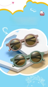 Detail of cute round frame kids sunglasses in brown and sage green with UV protection