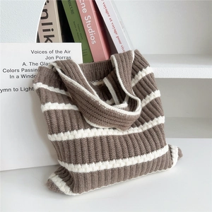 Detailaufnahme der braun-weiß gestreiften Stricktextur einer modischen Schultertasche