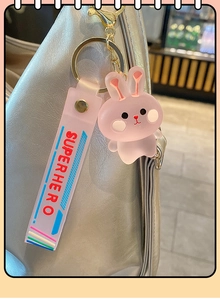 Porte-clés lapin rose mat avec sangle Superhero attaché à un sac à main argenté
