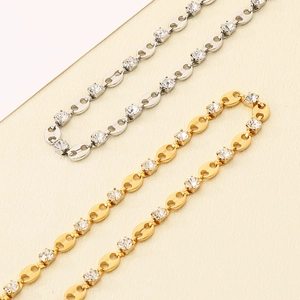 Detailed close-up of 18K gold and silver zircon-encrusted coffee bean chain links