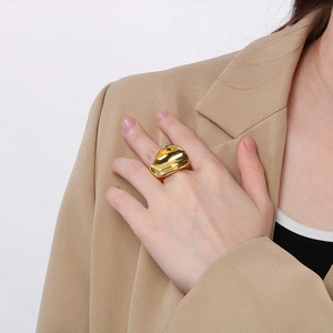 Detail of 18K gold plated wavy curve stainless steel ring worn on model hand