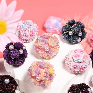 Close-up of colorful resin rose flower beads with pearl accents for DIY jewelry crafts