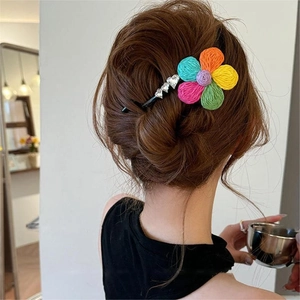 Dettaglio del fermaglio per capelli a fiori intrecciati con strass a cuore sui capelli